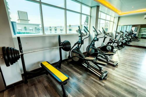 a gym with a row of treadmills and cardio machines at Grand Sya Hotel in Palu