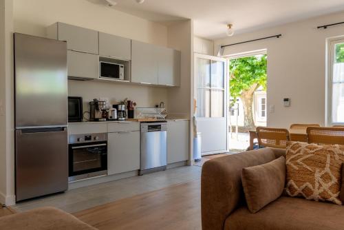 a living room with a couch and a kitchen at Plages à 50m - Spacieux appartement T4 - 8 couchages - résidence premium au calme - nature, village et port à pieds in Boyardville