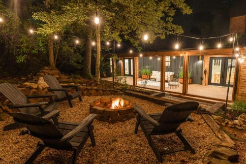 a backyard with chairs and a fire pit at night at Modern Mountain Retreat in Gatlinburg