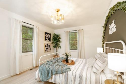 a white bedroom with a bed with a plant on it at Modern Mountain Retreat in Gatlinburg