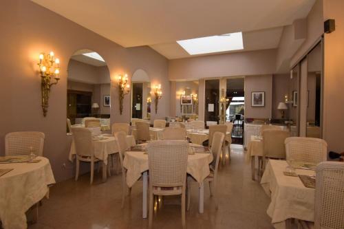 une salle à manger avec des tables et des chaises blanches dans l'établissement Hotel Dandy Rouen centre, à Rouen