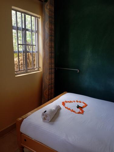 a bedroom with a bed with a towel on it at Longonot View Camp and Accommodation, Naivasha in Naivasha