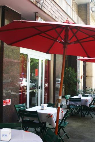a large red umbrella sitting on top of tables at Domus Hotel in Alessandria