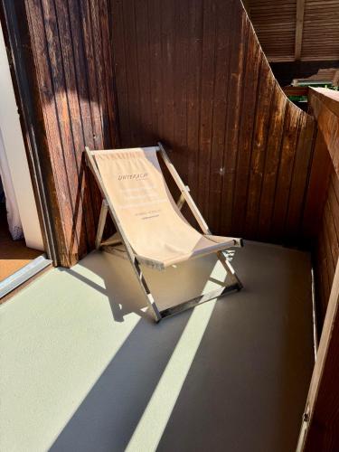 a folding chair sitting next to a wooden door at Apartment Naturhof Roithbauer in Buchenort