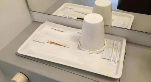 a table with a white tray with a toothbrush and aucer at Hotel Gran View Okinawa in Naha