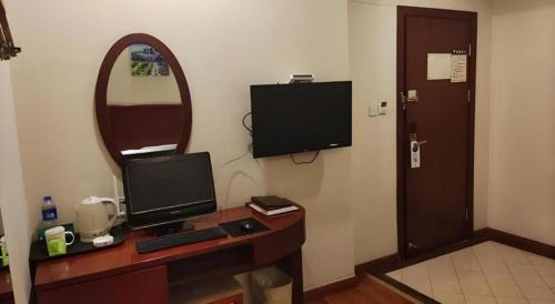 a room with a desk with a computer and a mirror at GreenTree Inn Datong YundinGYAyuan Express Hotel in Datong