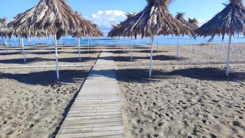 a pathway on a beach with some straw umbrellas at Stylish Apartment near the Beach with parking in Gázion