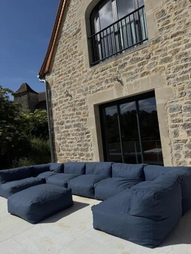 un canapé bleu assis devant un bâtiment en briques dans l'établissement domaine de Goubert Grande grange, à Miers