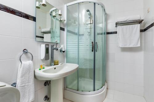 a bathroom with a glass shower and a sink at Xenios Possidi Paradise Hotel in Possidi