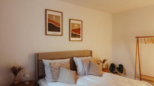 a bedroom with a bed and two pictures on the wall at Nordisches Premium Apartment in Wismar