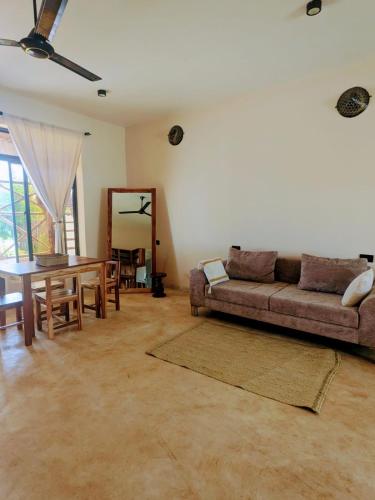 a living room with a couch and a table at Alcyone Residence - Ocean View Villa in Muyuni