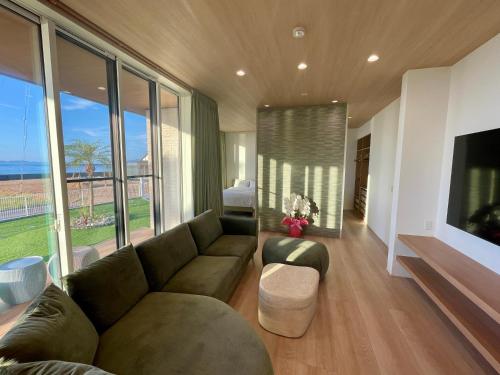 a living room with a couch and a large window at マール淡路島ラグジュアリービーチリゾート in Awaji