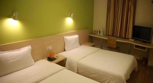 a hotel room with two beds and a television at 7 Days Inn Nanjing Xinjiekou Changfu Street Metro Station in Nanjing