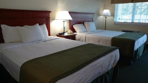 a hotel room with two beds and a window at Hurricane Inn in Waynesboro