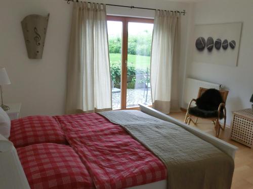 een slaapkamer met een bed, een raam en een stoel bij Ferienwohnung Mozart Bayreuth in Bayreuth