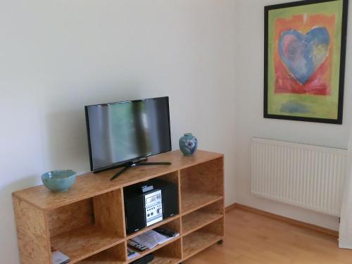 a flat screen tv sitting on a wooden entertainment center at Ferienwohnung Mozart Bayreuth in Bayreuth