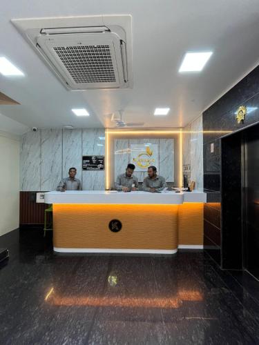 two men reflected in a mirror in a bathroom at Hotel Kavaka in Sambalpur