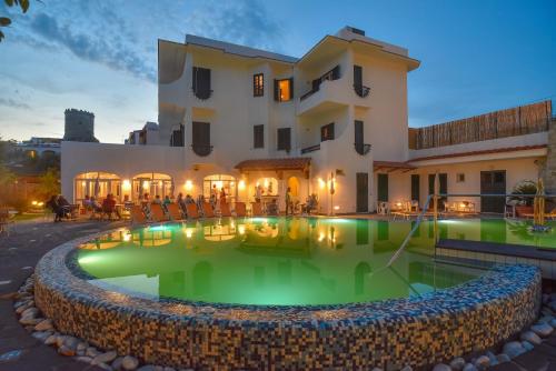 una casa con piscina di fronte a un edificio di Hotel Park Victoria a Ischia