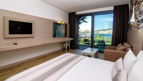 a hotel room with a bed and a large window at Costa Farilya Special Class Hotel Bodrum in Gundogan