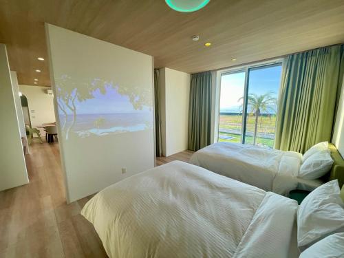 a hotel room with two beds and a large window at マール淡路島ラグジュアリービーチリゾート in Awaji