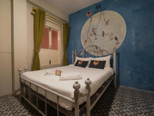 Un dormitorio con una cama con una pared azul. en 2499 Heritage Chinatown Bangkok Hotel By RoomQuest, en Bangkok