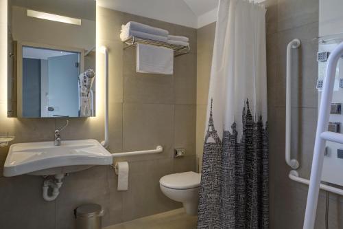a bathroom with a sink and a toilet and a shower at Hotel Liberty Self Check-In in Bellinzona