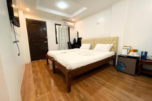 a bedroom with a large bed with white sheets at Pilot Hotel in Alaminos