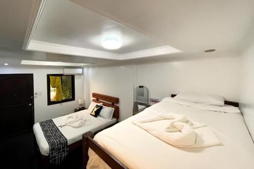 a small room with two beds and a ceiling at Pilot Hotel in Alaminos