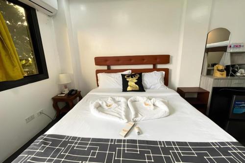 a bedroom with a bed with towels on it at Pilot Hotel in Alaminos