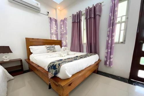 a bedroom with a large bed with purple curtains at Pilot Hotel in Alaminos
