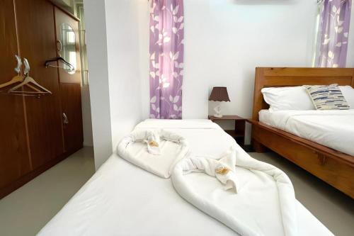 a bedroom with two beds with white sheets at Pilot Hotel in Alaminos