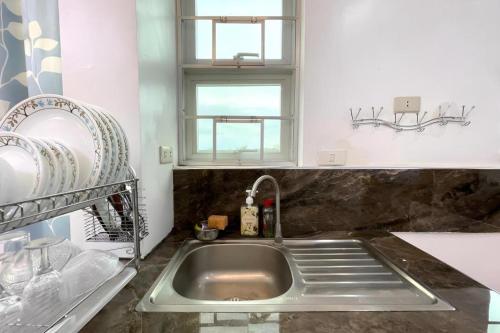 a kitchen with a sink and a window at Pilot Hotel in Alaminos