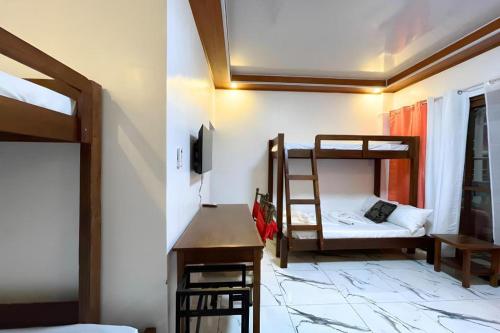 a room with two bunk beds and a desk at Pilot Hotel in Alaminos
