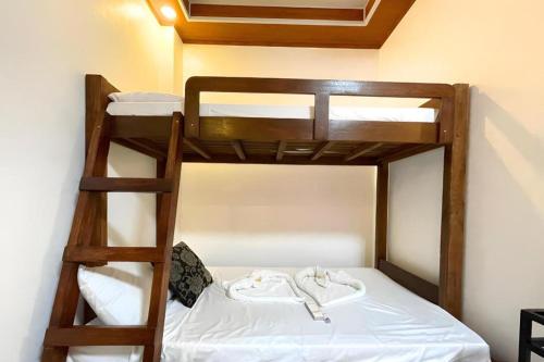two bunk beds in a room with white sheets at Pilot Hotel in Alaminos