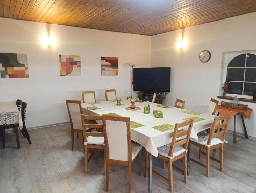 a dining room with a table with chairs and a television at Penzion SIESTA in Příbor
