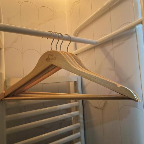 a wooden hanger on a rack in a closet at 上海璞逸酒店-豫园 新天地 老西门地铁站店 in Shanghai