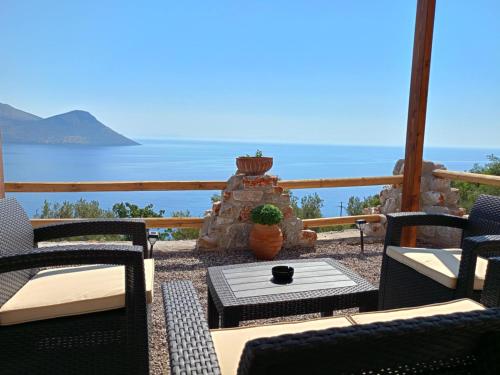 a patio with chairs and a table with a view of the ocean at Sofilia view house in Argilia