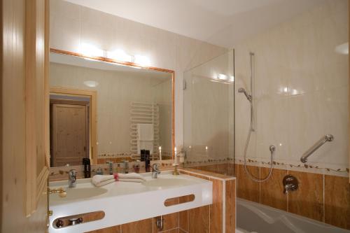 a bathroom with a sink and a shower and a mirror at Hotel Alpenpanorama in Söll