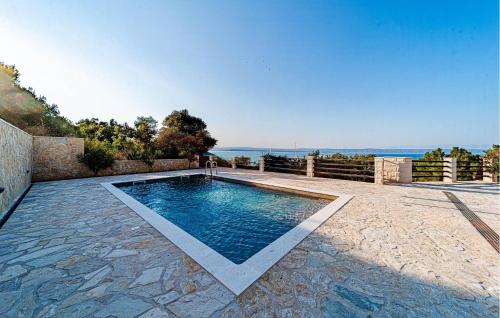 a swimming pool on a patio with the ocean in the background at Beautiful Home In Vela Luka in Vela Luka