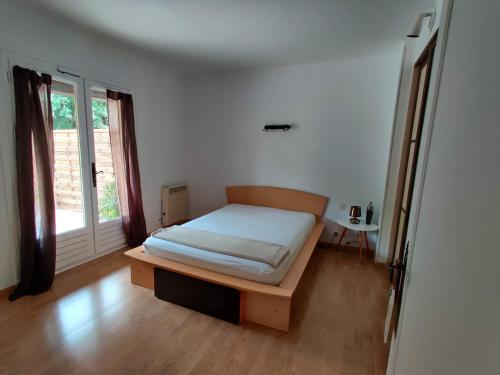 une chambre avec un lit et une fenêtre dans l'établissement Bas de villa indépendant. 10min de la mer, à Biot