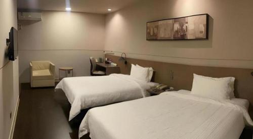a hotel room with two beds with white sheets at Jinjiang Inn Select Shanghai Fengxian Baolong Square North Yunhe Road in Shanghai