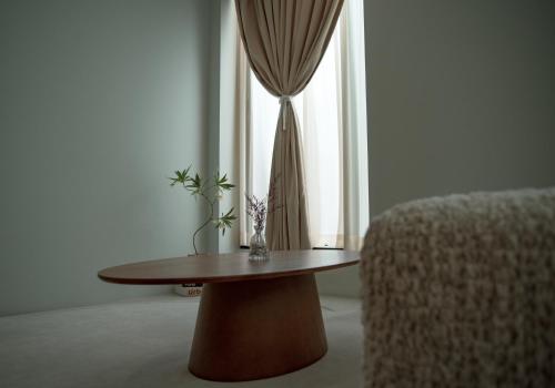 a table and a chair in a room with a window at Yeobaek Hotel in Incheon