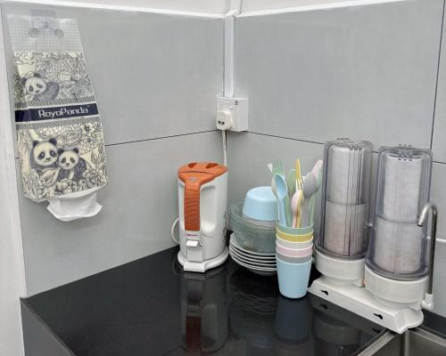 a kitchen counter with cups and plates on a table at 8 Paddy Escape Alor Setar, INS-Style, 3R 1B1T, Kid Toys, Bikes Rent in Simpang Empat