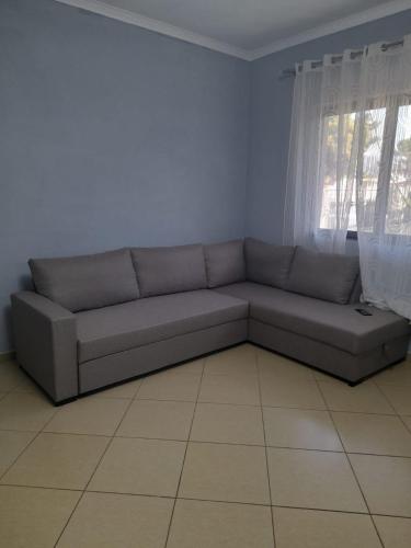 a couch in a living room with a window at Hidden Gem Vlora in Vlorë