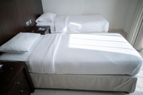 Postel nebo postele na pokoji v ubytování MENA ApartHotel Albarsha At The Mall