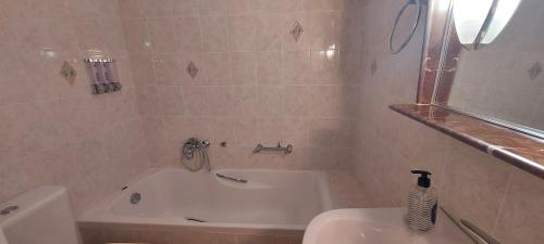 a bathroom with a tub and a toilet and a sink at Harmony 1 in Áyios Spirídhon