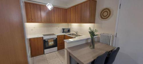 a kitchen with wooden cabinets and a table with a vase on it at Harmony 1 in Áyios Spirídhon