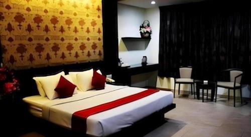 a bedroom with a large bed with red pillows at Hotel Bintan Nirwana in Tanjung Pinang 