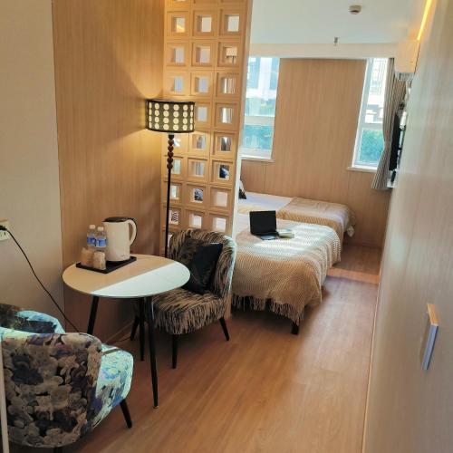 a room with two beds and a table and chairs at 上海璞逸酒店-豫园 新天地 老西门地铁站店 in Shanghai