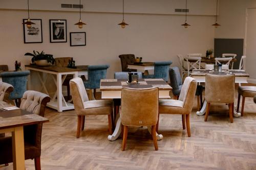 a restaurant with tables and chairs in a room at Hotel Cocoon in Ostend